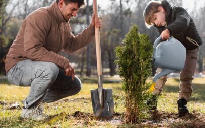 Personas plantando árboles en un jardín.