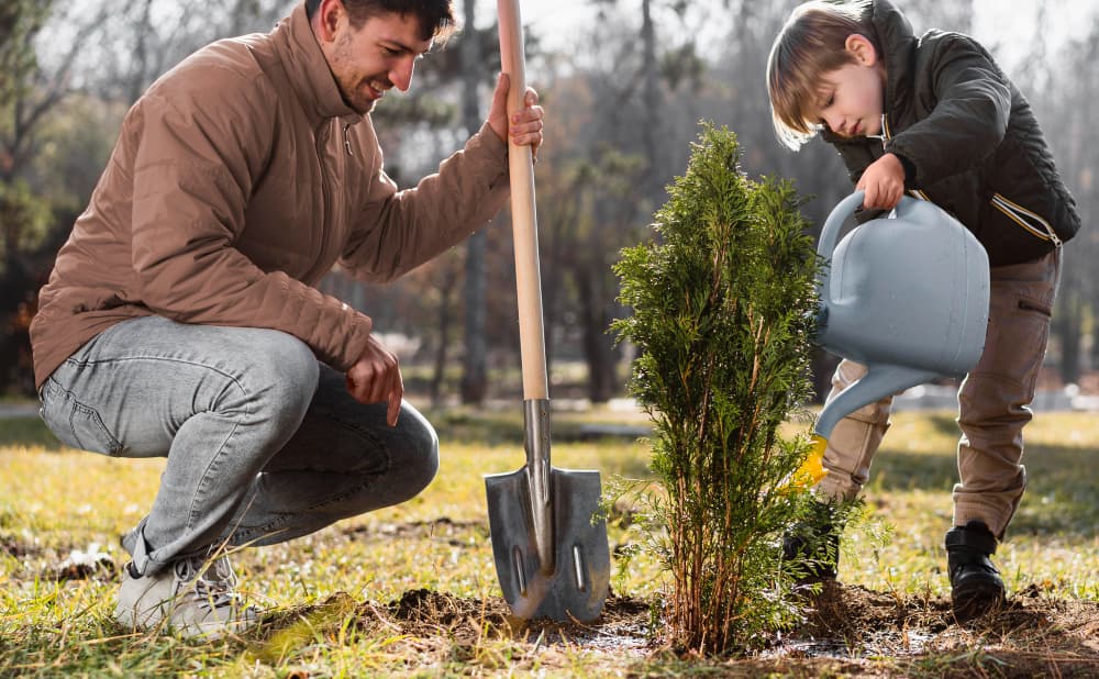 Personas plantando árboles en un jardín.