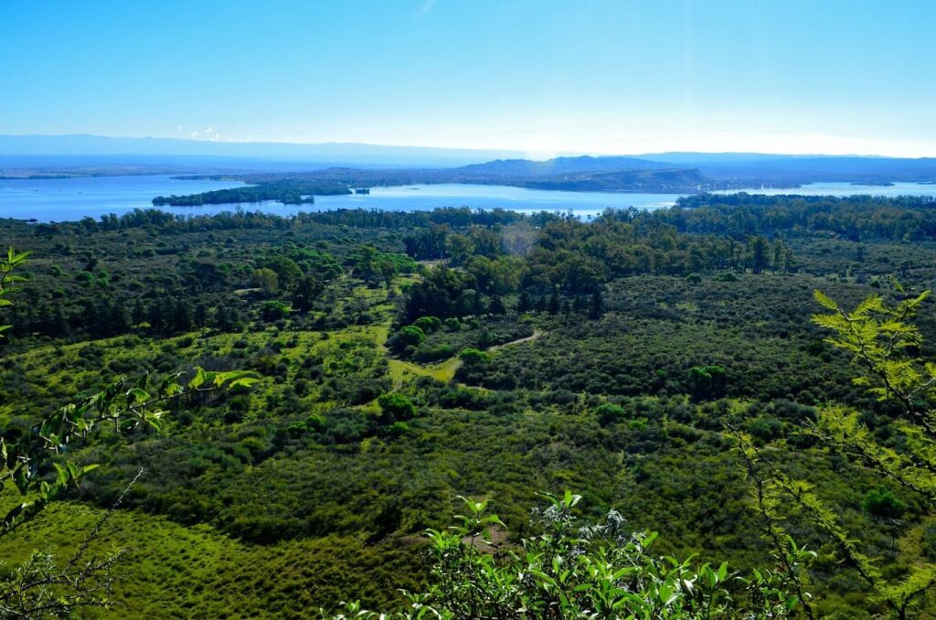 Paisaje de la Reserva Natural Educativa "Cerro Pistarini" con montañas y vegetación diversa.