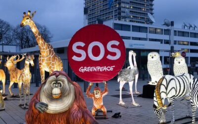 Instalación de Greenpeace con figuras de animales y un cartel rojo de SOS frente a la sede de la ONU.