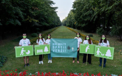 Grupo de jóvenes con mascarillas verdes sostiene carteles que promueven la creación de más áreas verdes en una ciudad, en medio de un parque arbolado.